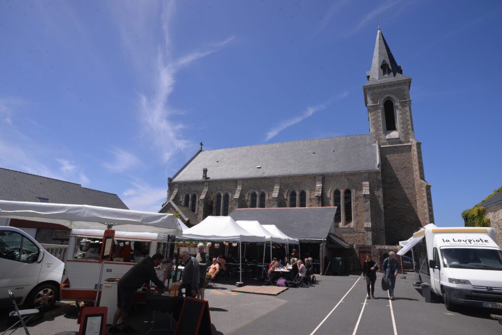 Marché extérieur devant église sous ciel bleu