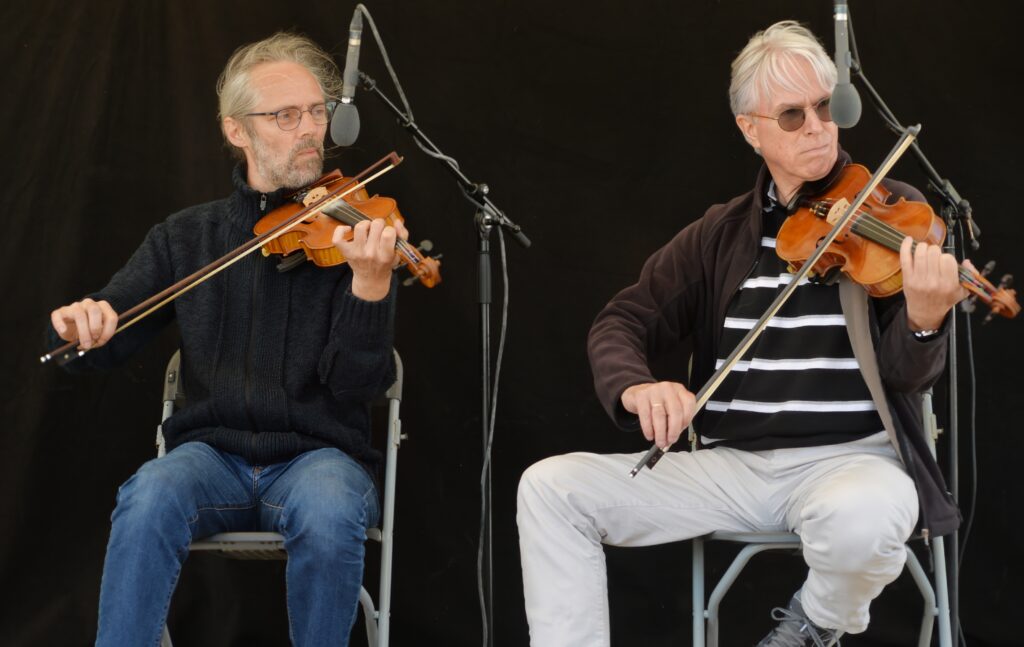 Deux hommes jouant du violon en concert live