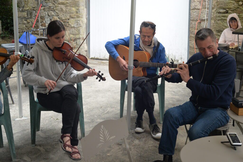 Trio jouant violon, guitare et flûte en extérieur