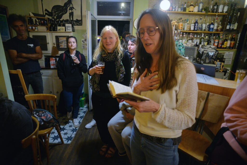 Femme lisant poème dans bar animé