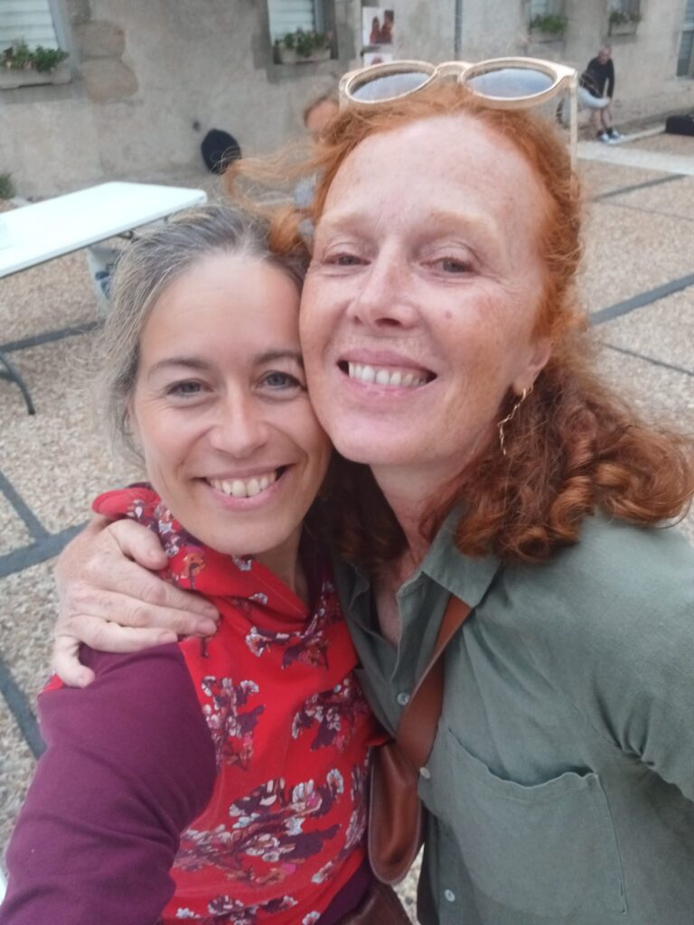 Deux femmes souriantes en étreinte amicale en extérieur