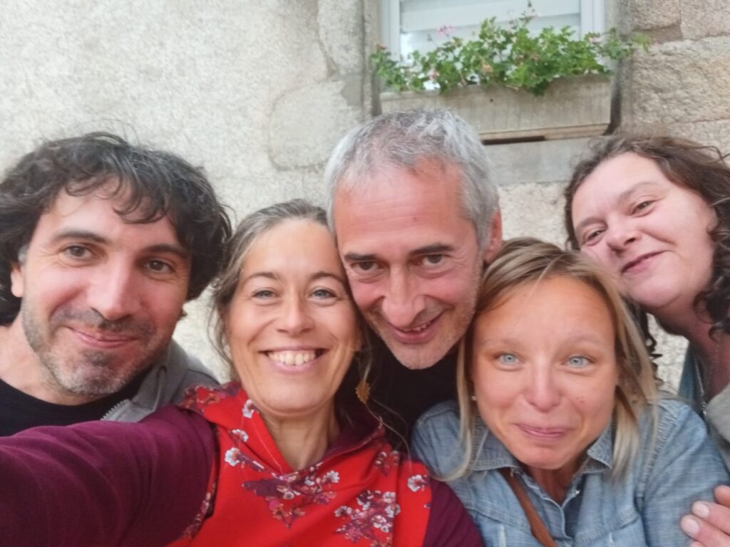 Groupe d'amis souriants devant une maison ancienne
