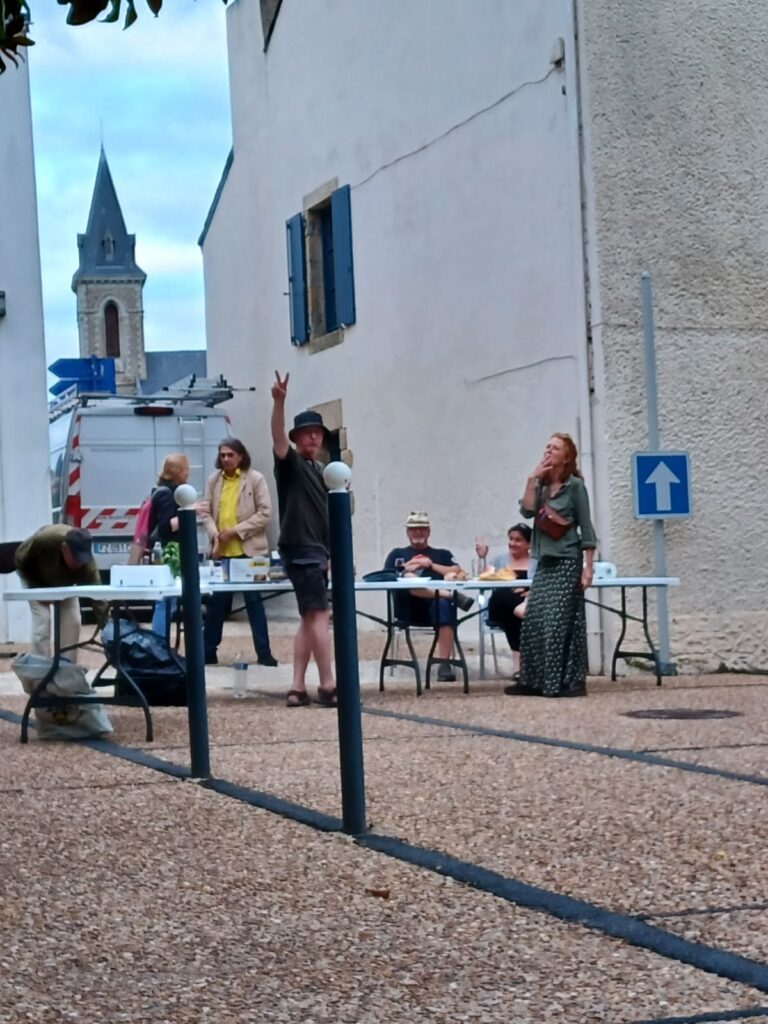 Personnes se détendant dans une cour villageoise.