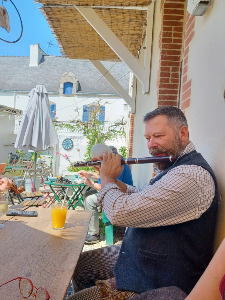 Homme jouant de la flûte dans une cour ensoleillée